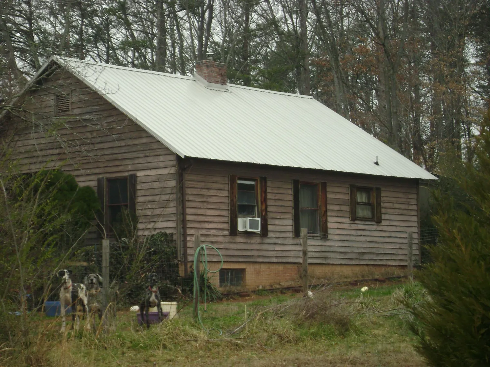 White metal roof on an old wood sided farmhouse, from a Metal Roof Installation job in Denton